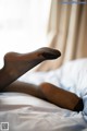 A woman laying on a bed with her legs crossed.