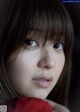 A close up of a woman with long brown hair and bangs.