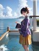 A woman in a purple kimono standing on a dock by the water.