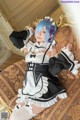 A woman in a maid outfit sitting on a couch.