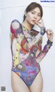 A woman in a colorful bodysuit posing for a picture.