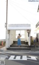 A woman standing in front of a white building.