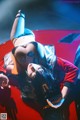 A woman laying on top of a red car.