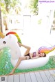 A woman laying on an inflatable unicorn in a pool.