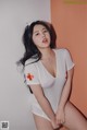 A woman in a white bodysuit with a red cross on it.