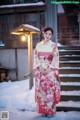 A woman in a kimono standing in the snow.