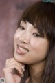 A close up of a woman with long brown hair smiling.