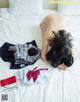 A woman laying on top of a bed next to a pile of clothes.