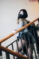 A woman wearing a face mask is walking down the stairs.