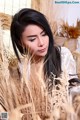 A woman sitting in a field of tall grass.