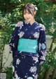 A woman in a blue and green kimono posing for a picture.