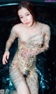 A woman in a bathtub with water on her body.